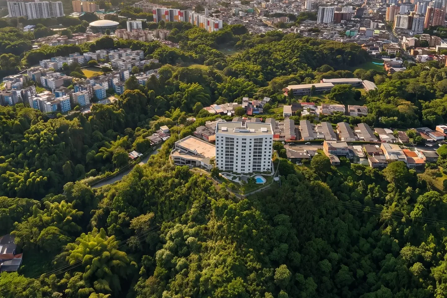 Fotografía aérea editada de la torre Alegranza sobre una ladera con vegetación y edificios de Armenia al fondo